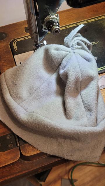Beanie cap in gray next to old black sewing machine