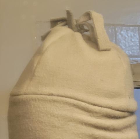 Someone's head with beanie cap, grainy crappy photo in a bathroom