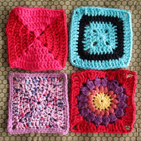 4 different granny squares on a green flower pattern fabric. The granny squares have mostly lilac, cyan, pink, red, and black colours.
