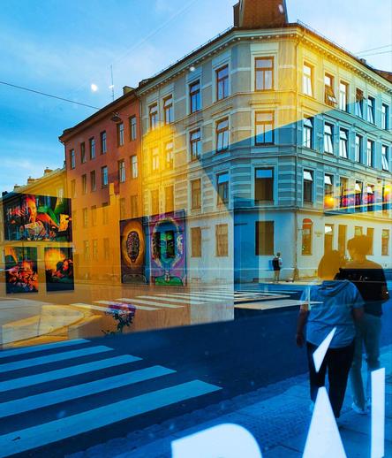 Одна из улиц Осло. Стекло витрины, в котором отражаются прохожие. За стеклом - небольшая выставка картин. Создается впечатление, будто люди разглядывают работы художников