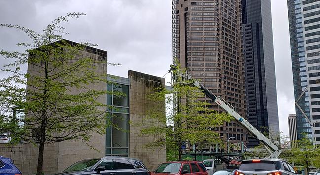 Hospital parking garage stair/elevator column exterior being pressure washed from a highlift.