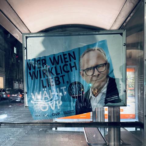 Ein Plakat von Mahrer, dass zerknüllt aus dem Rahmen unten herausrutscht. Sieht aus, als würde es schmelzen
