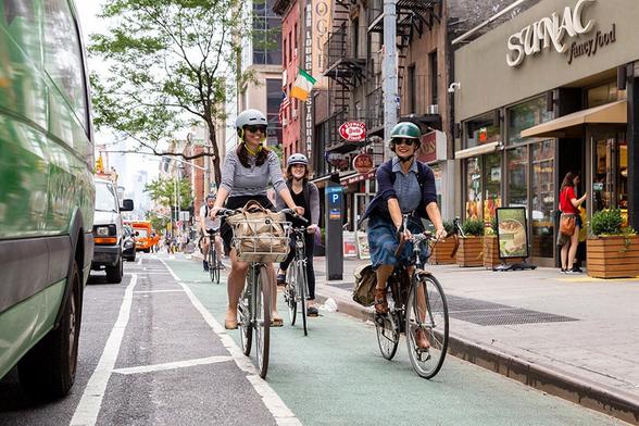 People riding in a painted, slightly separated bike-lane
