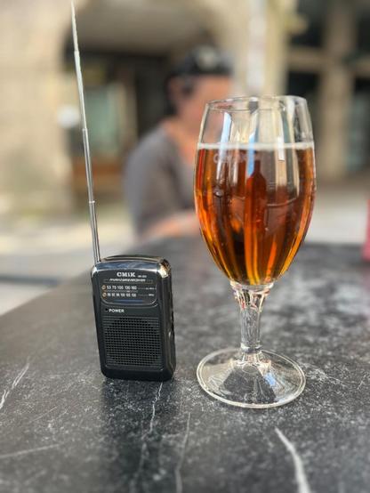 Cerveza y un radio transistor en una mesa de un bar