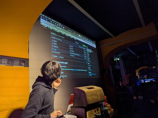 Presenter pointing at the projection of the GitHub repository of the project
