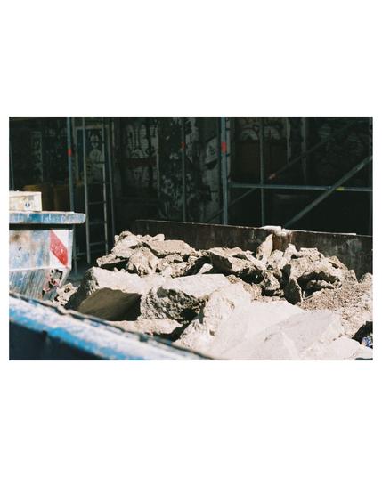 blue container of broken concrete pieces that are shining in the bright sunlight.
