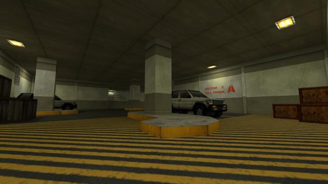 In this picture you can see an underground parking lot. From left to right you can see three dark brown wooden boxes, two of which are standing on the ground and the third is standing on top of another, a open ventilation shaft, a pillar, behind it is a white SUV, a staircase leading to a door, two more pillars, another white SUV and three light brown wooden boxes, where two are standing on the ground and one is standing on top. Furthermore, three yellow lamps are visible on the ceiling. And next to the second SUVs, the wall says in red: Sector E Mat. Trans. A. This is on the map cs_siege in the game Counter-Strike 1.6.