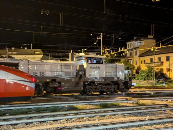still the same train, but only the diesel locomotive behind the parked Frecciarossa is seen