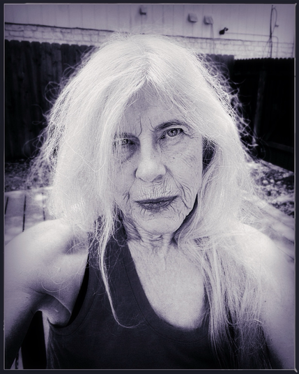 Woman from shoulders up. White hair, direct stare.