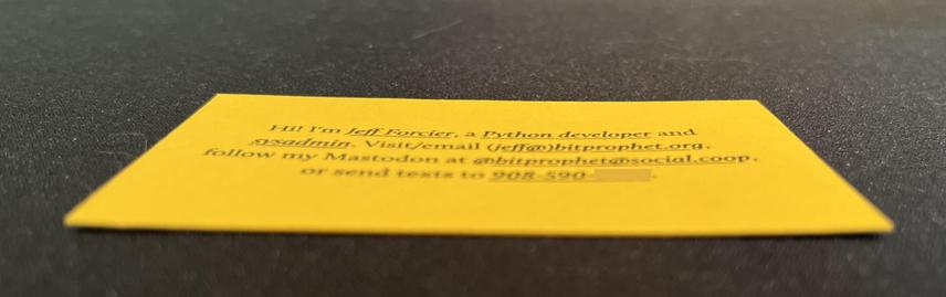 Photo of business card from previous, but at a sharp angle to give a slight sense of the thickness of the cardstock. Sadly, it’s kinda blurry and out of focus, because cameraphone.
