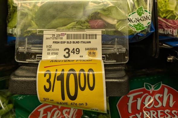 A shelf tag for a bag of Italian salad mix in a Safeway store. The regular price is $3.49, but a yellow tag below offers 3/$10.00, save 47 cents on 3. And in very small type, $3.33 each.
