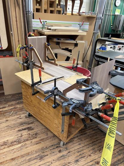 Two opposite corners of the cabinet are being glued together.