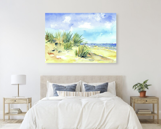Beach Summer is a landscape format watercolor painting by artist Karen Kaspar. In the foreground are sandy dunes overgrown with seagrass in various shades of green. In the background is the blue sea with white crests of waves. Above it stretches the blue summer sky with little white clouds. The watercolor painting is painted with loose, expressive brushstrokes and radiates summery freshness.
