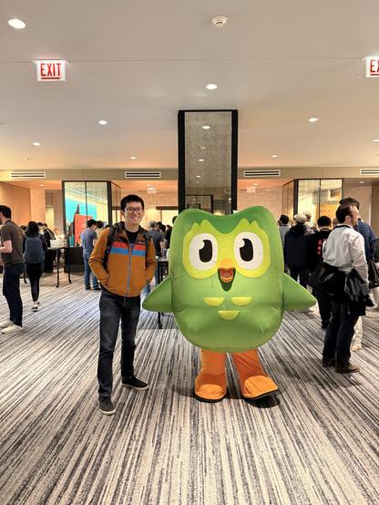 Me standing next to Duo, the Duolingo owl mascot