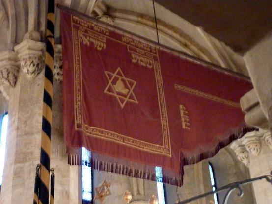 red and gold banner hanging inside a gothic synagogue, Prague