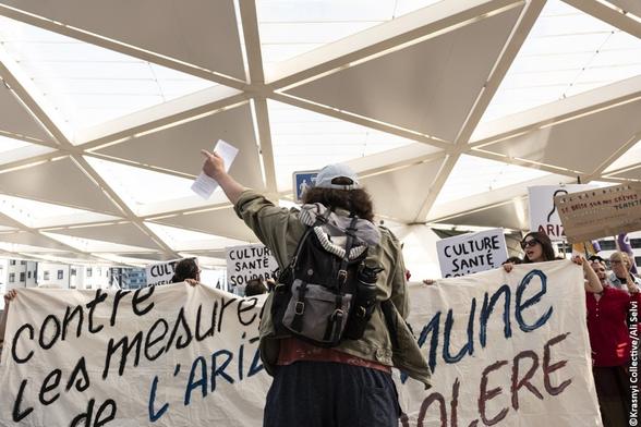 Des manifestants, un panneaux: "CONTRE LES MESURES DE L'ARIZONA"