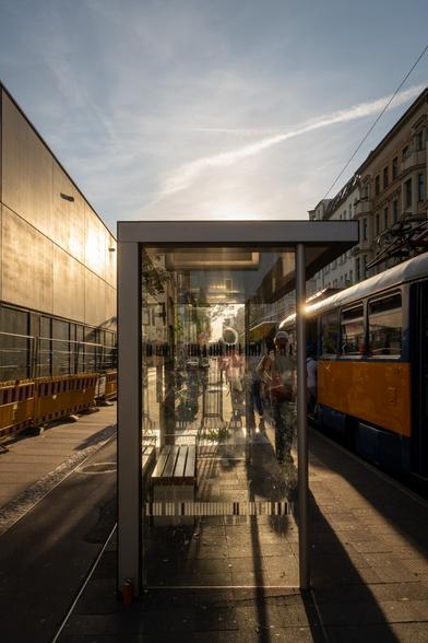 Wartehäuschen aus Metall und Glas im Gegenlicht der untergehenden Sonne.