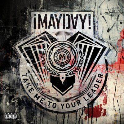 A gritty, urban-style album cover featuring a geometric emblem in the center with symmetrical, wing-like shapes and a laurel wreath surrounding a central symbol. The text “¡MAYDAY!” is boldly written above, with “Take Me to Your Leader” curved along the bottom of the emblem. The background has a grungy, painted wall texture with smudges, drips, and distressed colors, suggesting rebellion and underground energy.