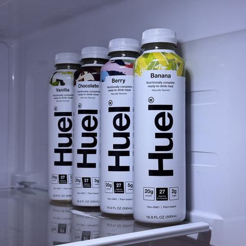Four bottles of ready-to-drink Huel in my fridge, flavors being banana, berry, chocolate and vanilla