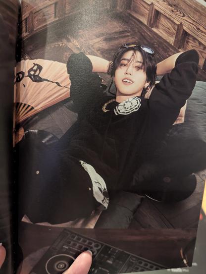 Han reclining on the floor, leaning back against a large cushion, with his hands behind his head