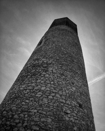 Black and white photo of the cylindrical tower of the Olsztyn Castle.
