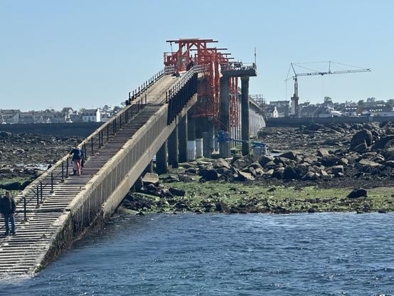 Pontsteiger bij Roscoff in Bretagne bij laag water en springtij.  Foto vanaf de aankomende pont met de steiger hoog op palen boven de drooggevallen zeebodem.