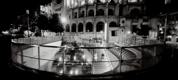 exit of "les halles" in paris, in front of a church, black and white, at night