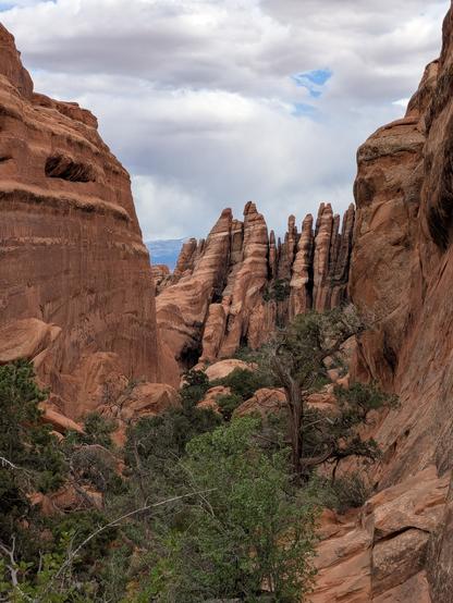 vertical sheets of red sandstone seen thru a narrow gap in the stone