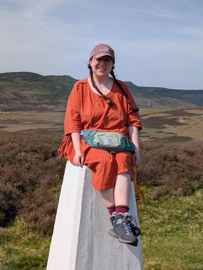 My daughter sitting on a trig point