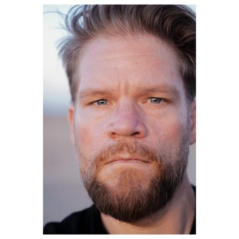 Photo my son took of himself, it’s a closeup of his face, and he’s a very fair 40-something w/ dark blonde short hair and a full beard w/ some grey in it, he has piercing blue-grey eyes and a serious facial expression