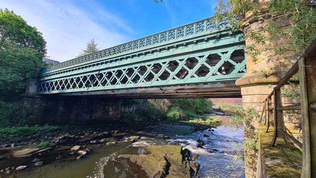 A cast iron Victorian bridge carrying a road over the River Kelvin in Glasgow.