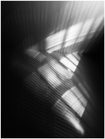 Contrasty abstract of light reflecting on a wall through blinds