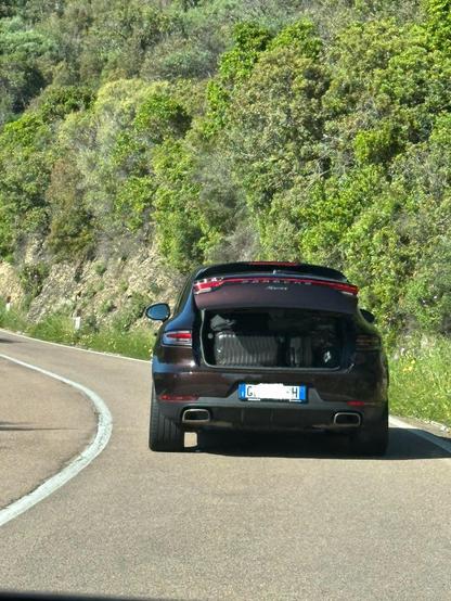 Porsche Macan with almost completely open trunk. Now we have full view of most of the luggage. 🤭