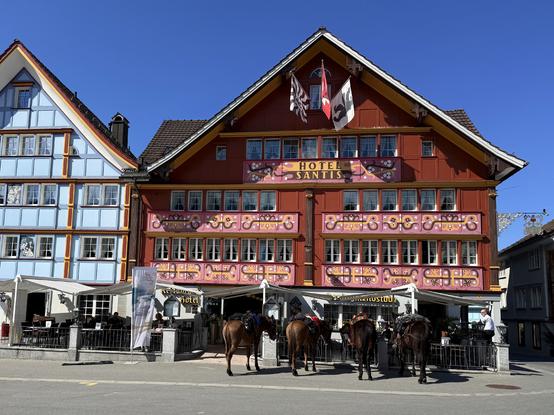 vor dem traditionellen hotel am appenzeller landsgemeindeplatz stehen gesattelte pferde