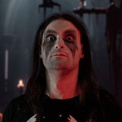 Julian, mit verwaschenem Corpsepaint, schaut mit aufgerissenen Augen in die Kamera