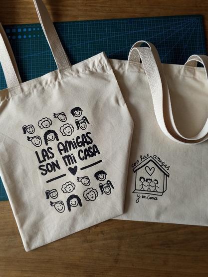Primer plano del diseño “LAS AMIGAS SON MI CASA” con detalles de rostros y letras estampadas en vinilo textil brillante.