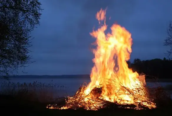 A bonfire at night, by the waterside