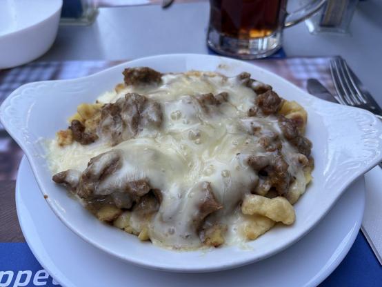 Käse-Spätzli-Pfanne mit Spätzli, Kalbfleisch geschnetzeltes mit etwas Rahmsauce und Käse überbacken