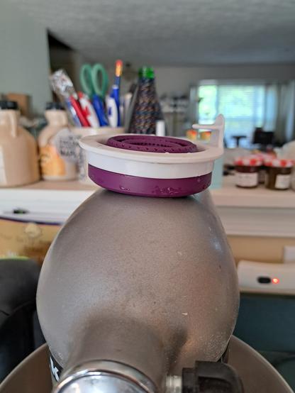 Collapsed collapsing tea infuser sittin on top of a KitchenAid stand mixer