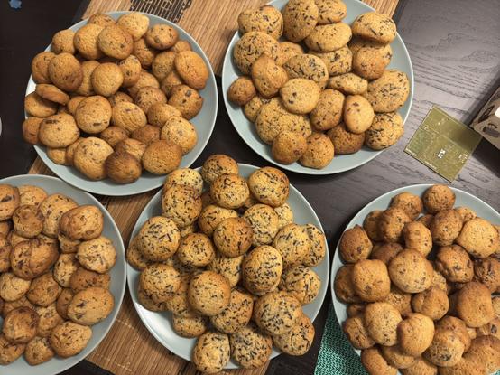 5 plates full of cookies with varying degrees of chocolate chippage