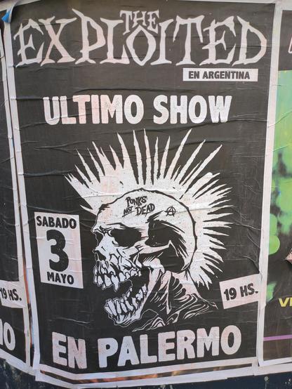 Cartel en blanco y negro en la calle del show de The Exploited en Argentina. Está la calavera con cresta con un tatuaje de "punks not dead" y dice sábado 3 de mayo en Palermo 19hs en Palermo.