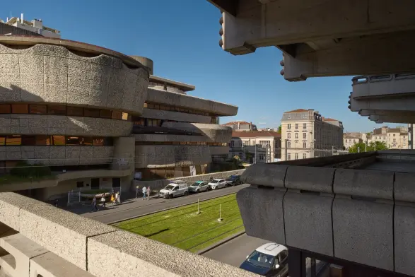 Photo d'un immeuble aux formes arrondies depuis les terrasses d'en face.