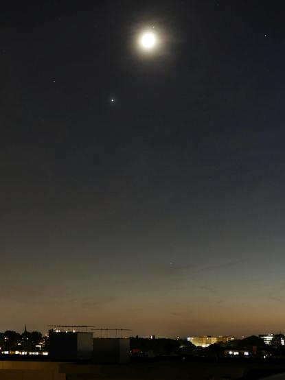 The pair - Moon overexposed - over the city