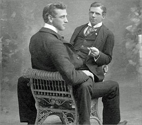 A vintage photograph of one rather dapper Edwardian gentleman sitting astride another.