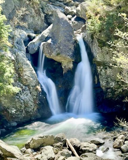 Photo of large waterfall taken at a distance. It is 60 feet (18 meters) tall and is falling down a rock gorge. Large boulders at the base.

Bash Bish Falls. Mt Washington, Massachusetts.