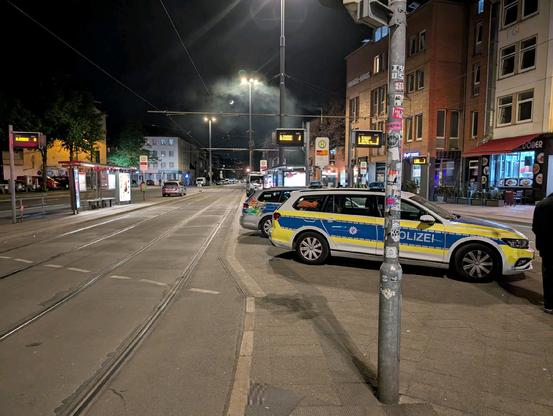 4 Polizeiautos stehen auf der Straßenbahnhaltestelle, während die Straßen drum herum leer sind.