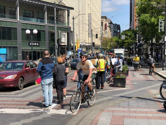 A person bikes in the human-protected bike lane.