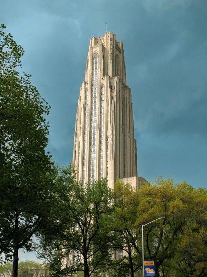 Dark grey and stormy cloudy sky with the cathedral of learning stone tower