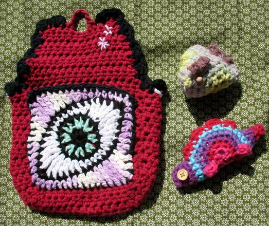 Pouch from the back with an eye granny square that is a pocket and again the chicken and stegosaurus.