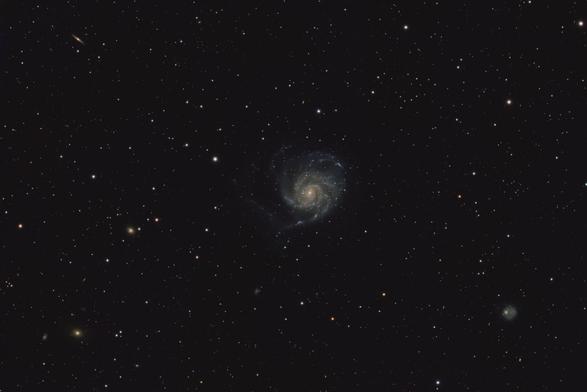 A field of stars with a large asymmetrical spiral galaxy in the center